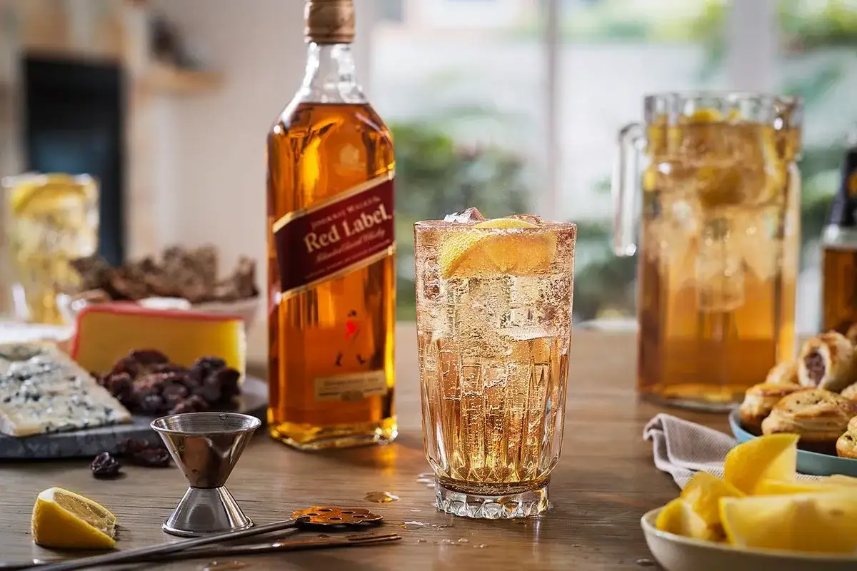 Orzeźwiający drink z Red Label, podany z lodem i cytryną, obok przekąsek i sera. Idealny na letnie wieczory.
