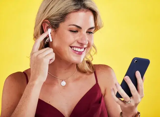 Osoba słuchająca radia FM na smartfonie ze słuchawkami