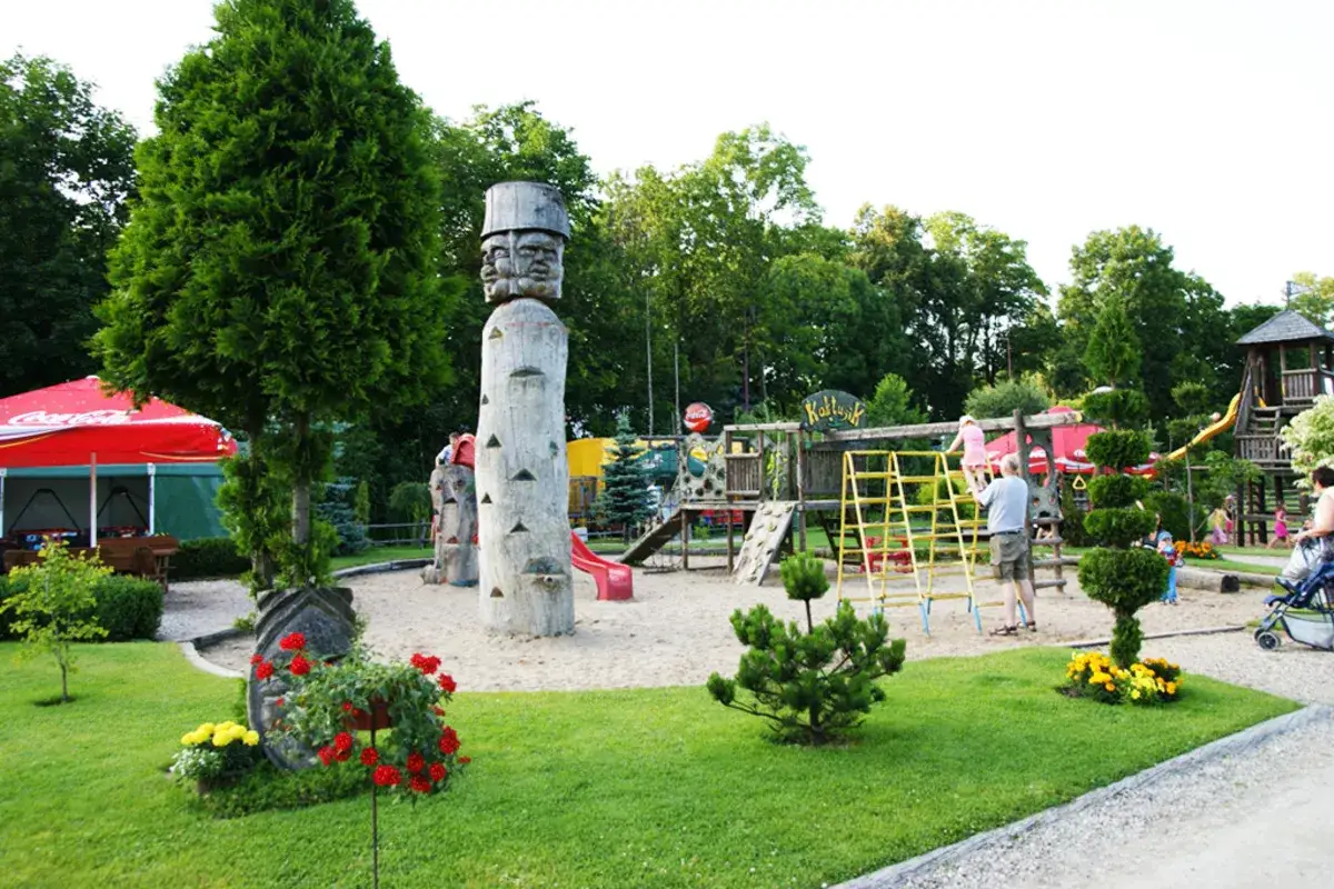 Wesołe miasteczko w Augustowie oferuje mnóstwo atrakcji dla dzieci: zjeżdżalnie, drabinki i drewniane rzeźby.