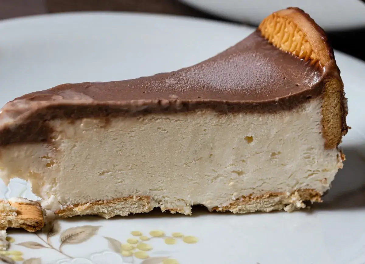 Pyszny kawałek sernika z polewą czekoladową, idealny na dietetyczne ciasto z kaszy manny. Kruchy spód i kremowe wnętrze.