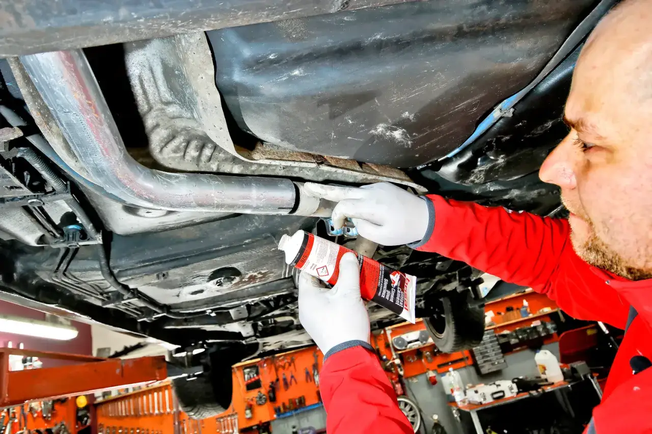 Mechanik stosuje pastę do łączenia wydechu bez spawania.