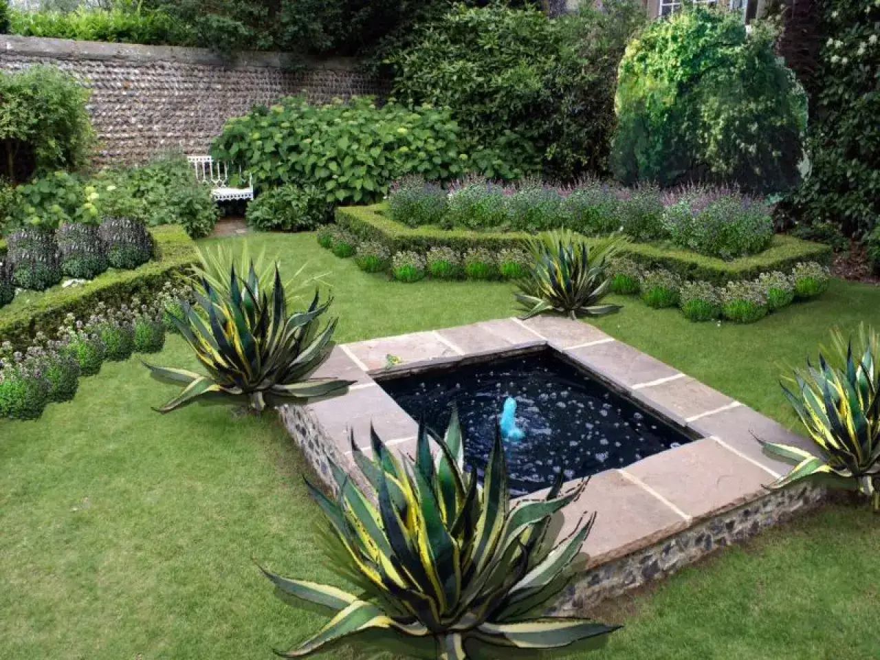 Piękny ogród z oczkiem wodnym, agawami i kwitnącymi rabatami. Inspiracje na zioła w ogrodzie.