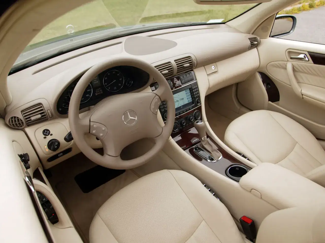 Wnętrze Mercedesa W203 2.2 CDI z jasną tapicerką, kierownicą i deską rozdzielczą.