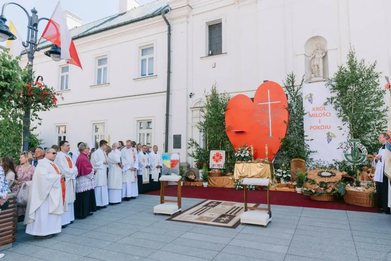 Uroczystość Najświętszego Ciała i Krwi Chrystusa. Procesja z wielkim sercem i krzyżem. Kapłani w białych szatach.