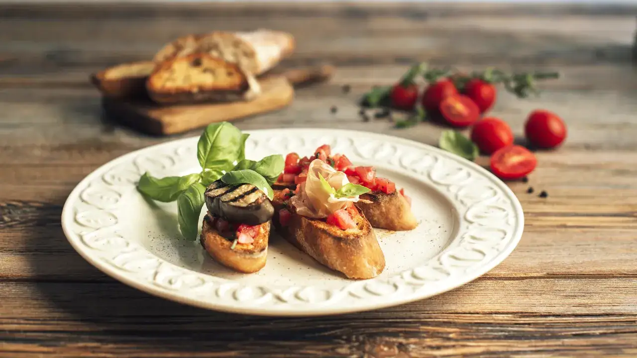 Bruschetta z pomidorami, bakłażanem i szynką parmeńską. Idealna inspiracja, co ugotować na walentynki.