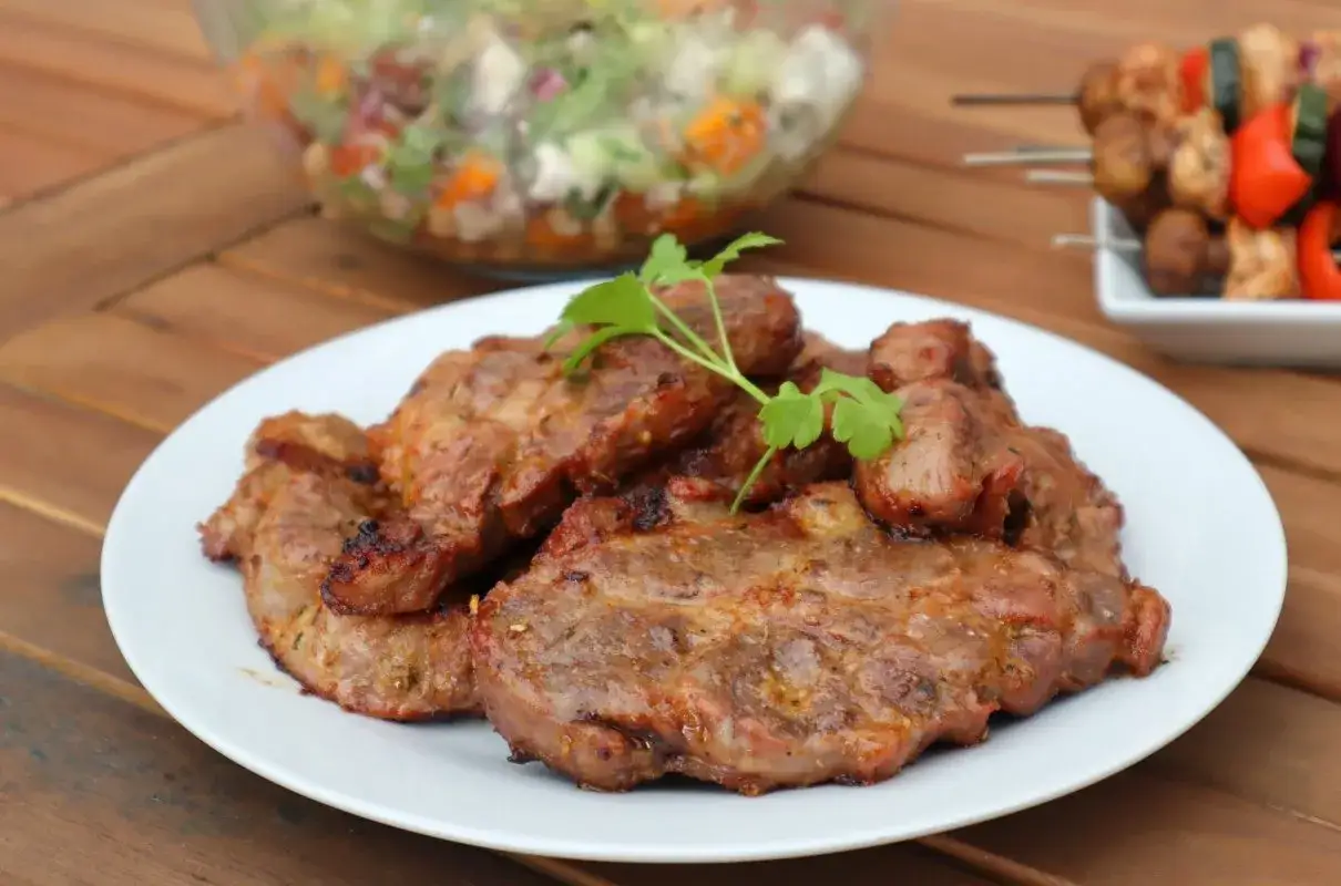 Soczysta łopatka z grilla, idealna na letnie popołudnie. Podana z sałatką i szaszłykami.