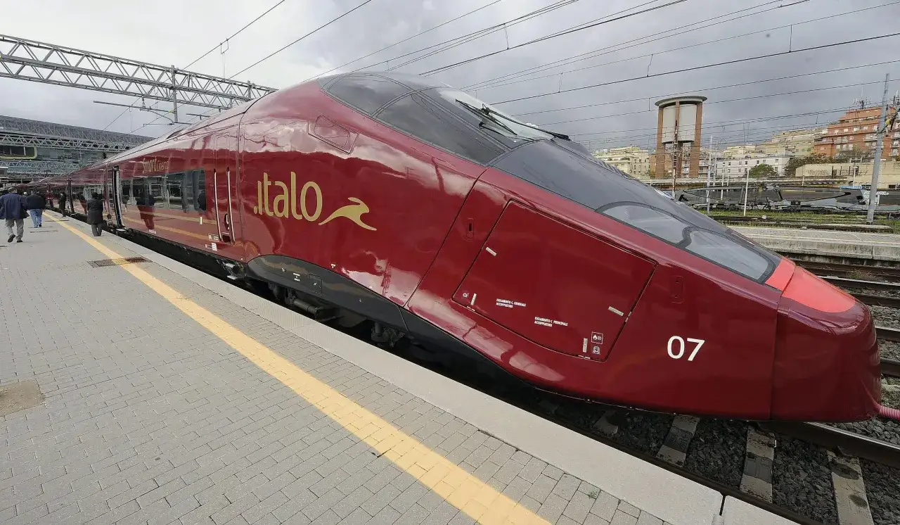 Czerwony pociąg Italo, najszybszy pociąg w Europie, stoi na peronie.