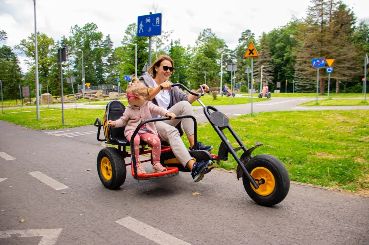Mama i córka ścigają się na rowerku w Rabce Zdroju. Radosna przejażdżka po miasteczku ruchu drogowego.
