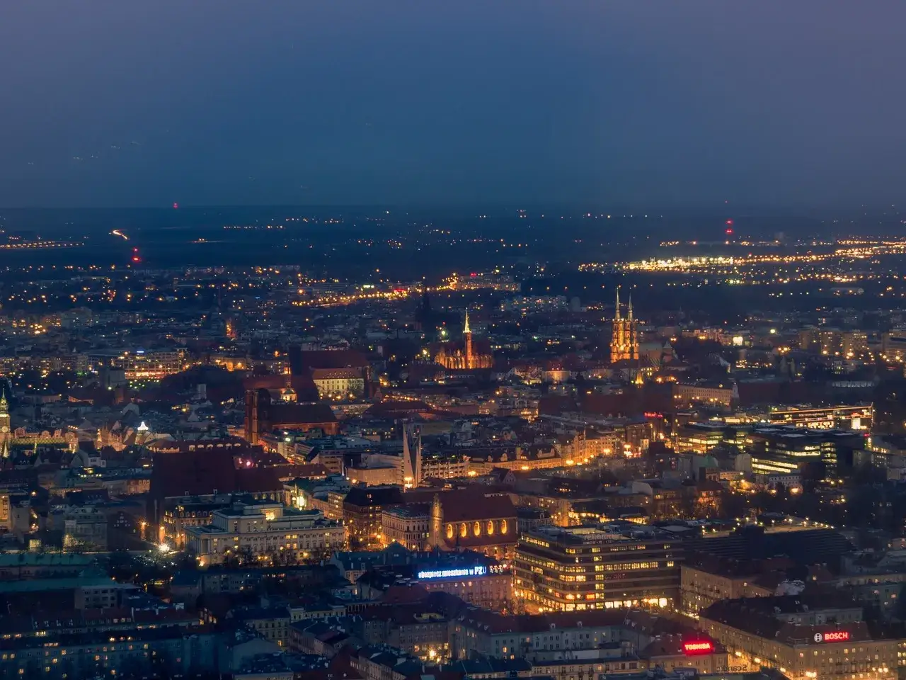 Nocny widok na Wrocław z góry. Rozświetlone miasto, kościoły i budynki tworzą magiczny krajobraz. To idealny punkt widokowy Wrocław.