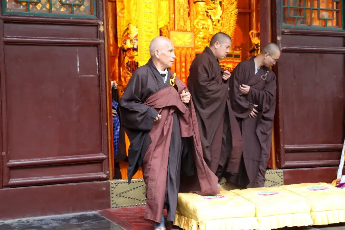 Mnisi w brązowych szatach wychodzą z świątyni. W Azji, gdzie jest najwięcej buddystów, takie widoki są powszechne.