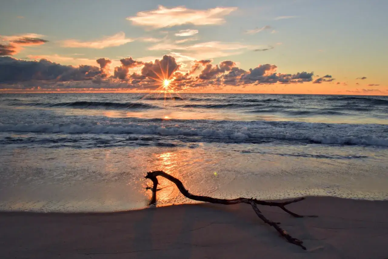Zachód słońca nad morzem, idealny na wczasy dla seniora nad morzem z wyżywieniem. Spokojne fale i ciepłe barwy nieba.