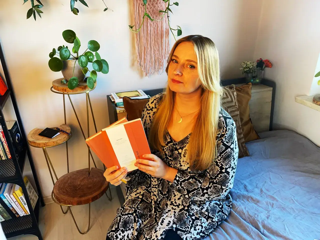 kobieta pisząca w notatniku zamyślona nad poprawną pisownią