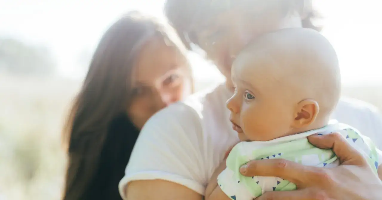 Rodzice patrzą na swoje dziecko, zastanawiając się, po kim dziecko dziedziczy inteligencję.