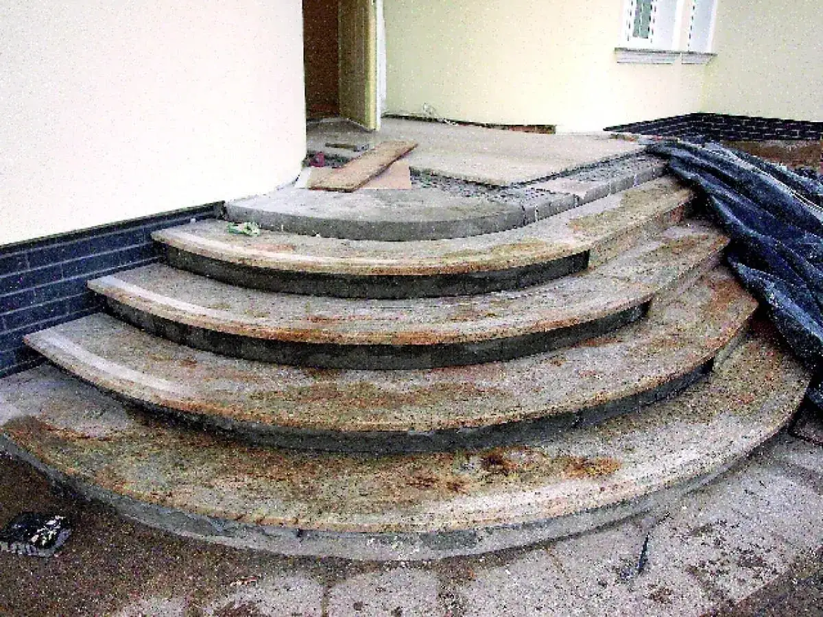 Jak odnowić stare schody betonowe zewnętrzne? Widać tu prace remontowe, przygotowanie do renowacji krętych schodów.