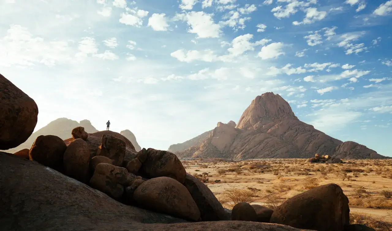 Samotny podr&oacute;żnik podziwia majestatyczne formacje skalne Spitzkoppe w Namibii.