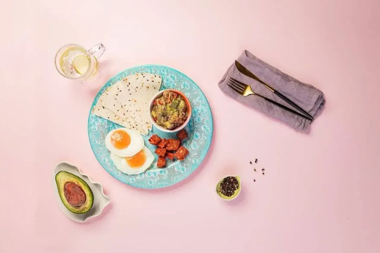 Zdrowe śniadanie: jajka sadzone, tortille, guacamole i awokado. Inspiracja na przepisy na zdrowe posiłki.