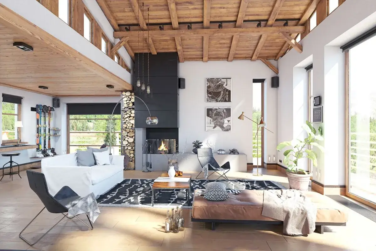 Przytulne wnętrze domu w stylu wiejskim z kominkiem, drewnianym sufitem i widokiem na zieleń.