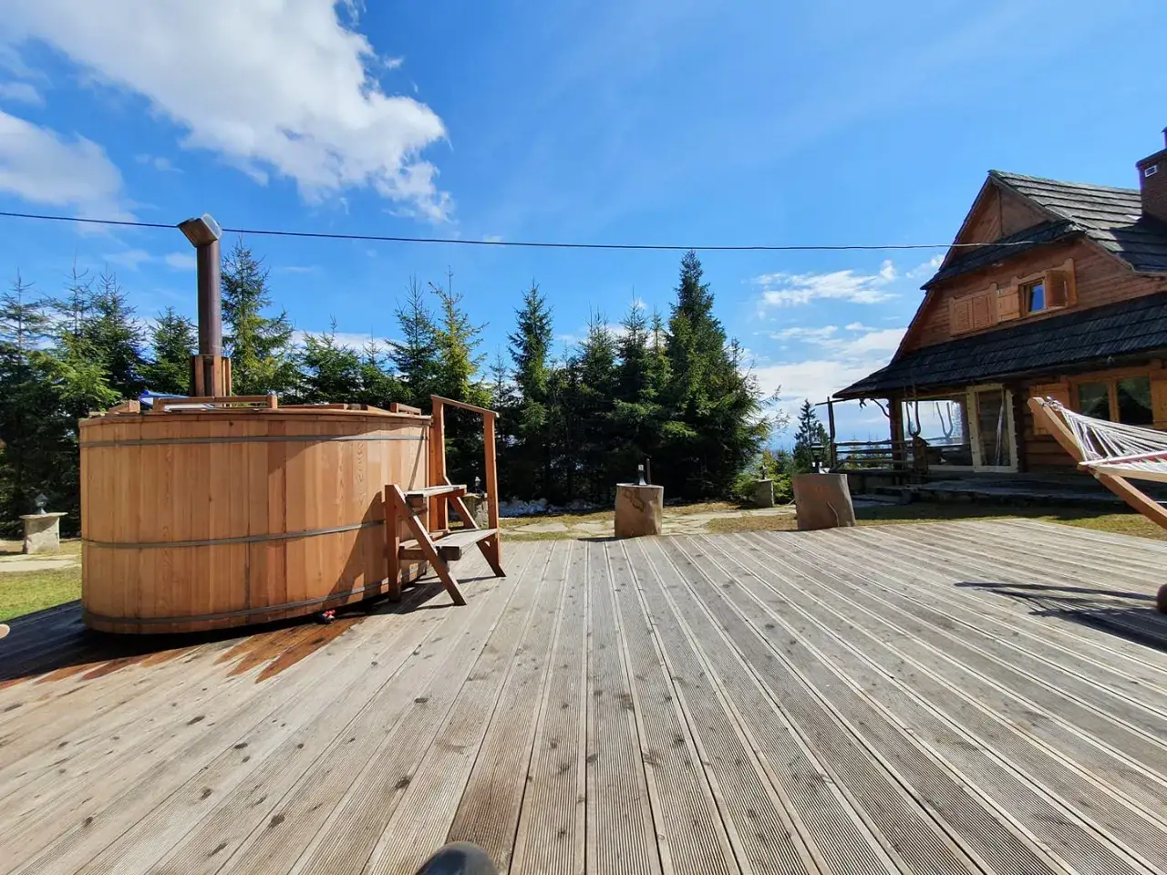 Drewniana beczka z gorącą wodą i dom w stylu bac&oacute;wka u dudka. Idealne miejsce na relaks w g&oacute;rach.