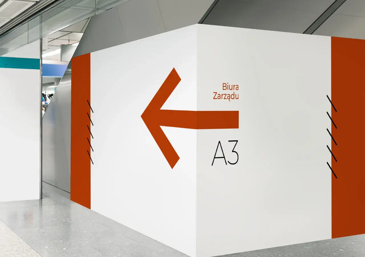 Przykłady element&oacute;w stylizacji środowiskowej: wayfinding, branding 3D, grafika wielkoformatowa