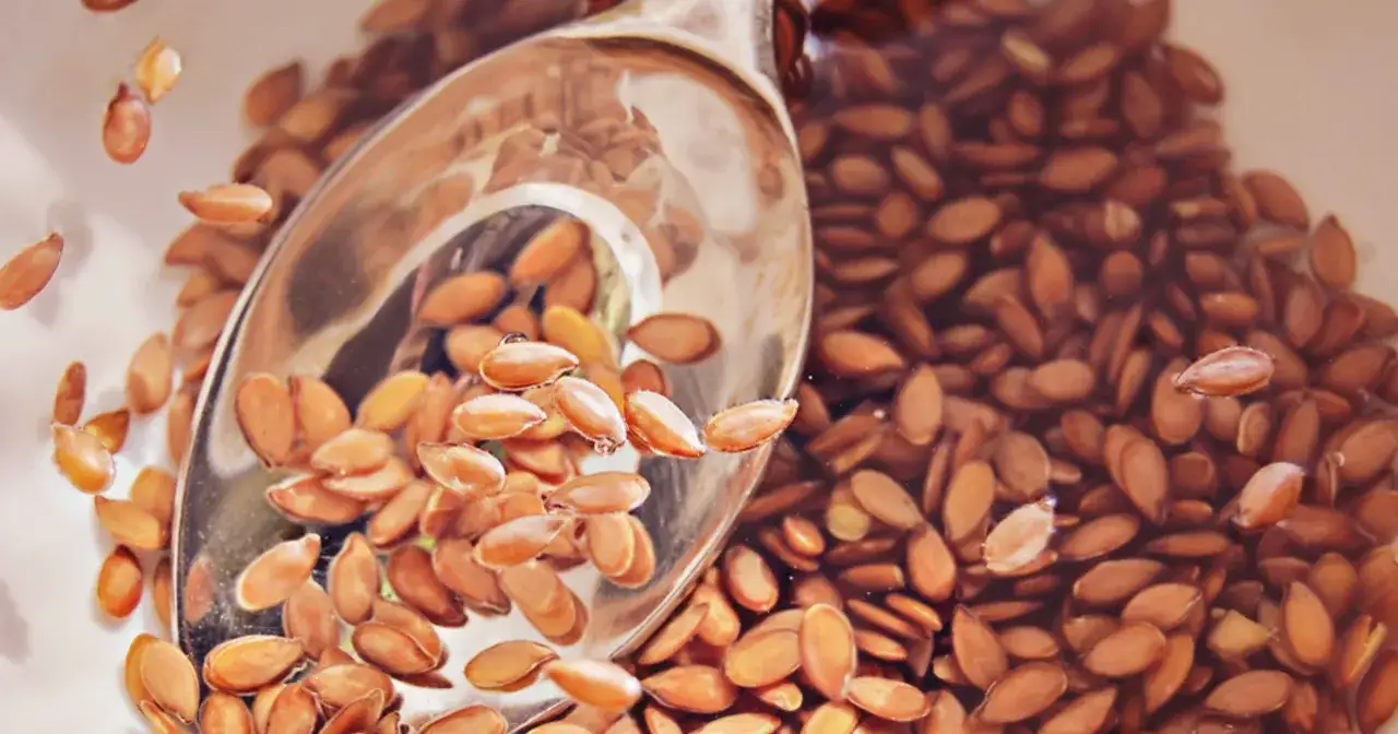 Sięgnij po siemię lniane, gdy czujesz zgagę. Łyżka pełna ziaren w wodzie, gotowa do pomocy.