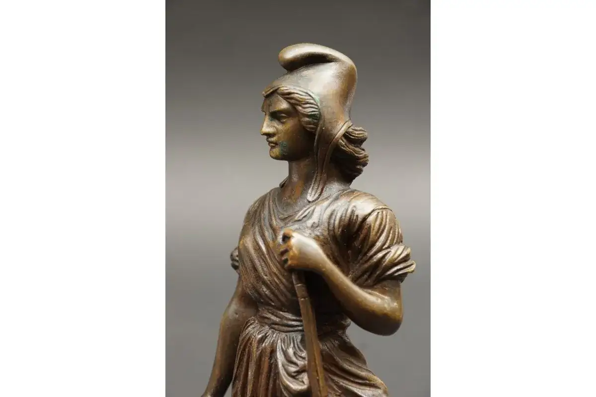 Brązowa figura kobiety w hełmie, symbol Republiki Francuskiej, trzymająca laskę.