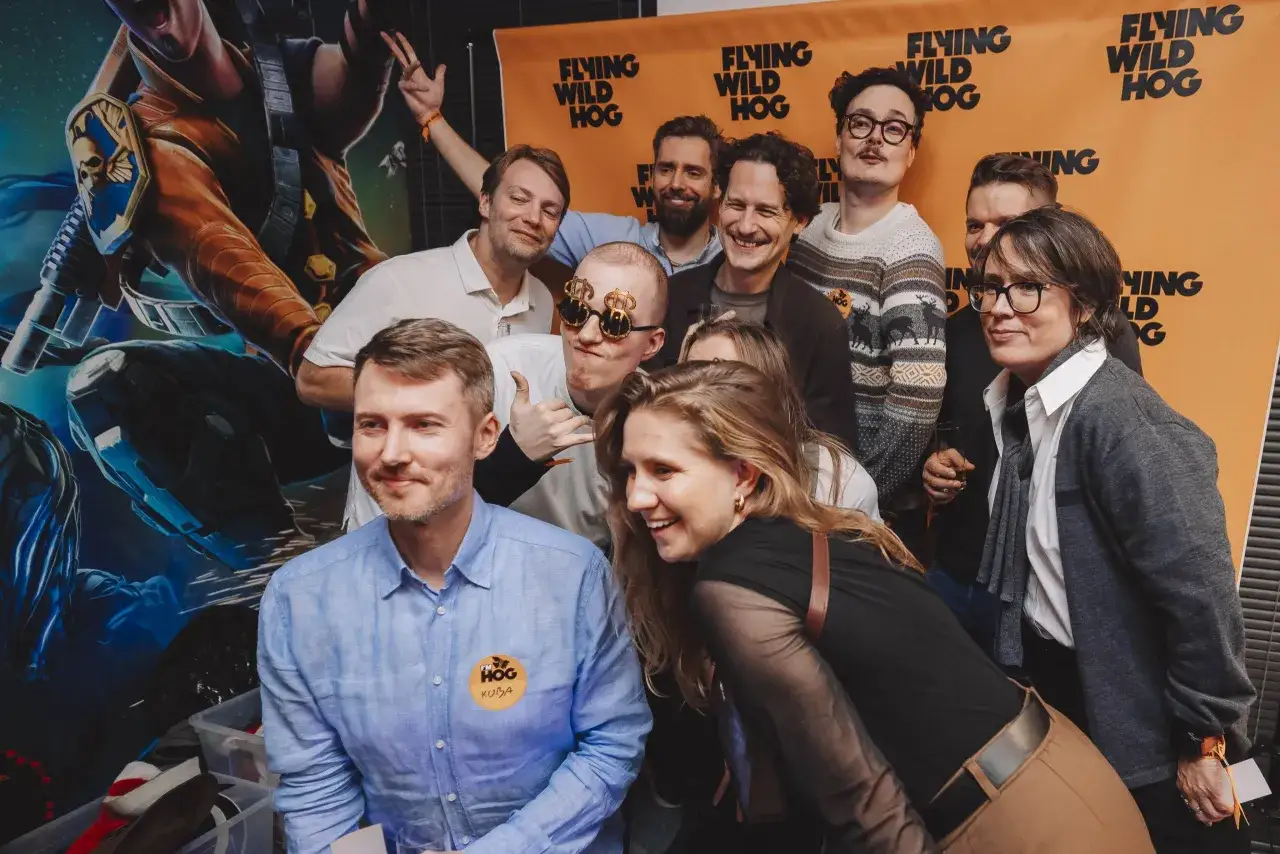 Grupa ludzi pozuje do zdjęcia na tle banera 