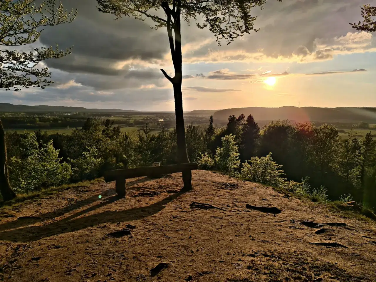 Ławka na wzg&oacute;rzu, idealne miejsce na odpoczynek podczas spaceru po ścieżce zdrowia Luzino. Zach&oacute;d słońca nad doliną.
