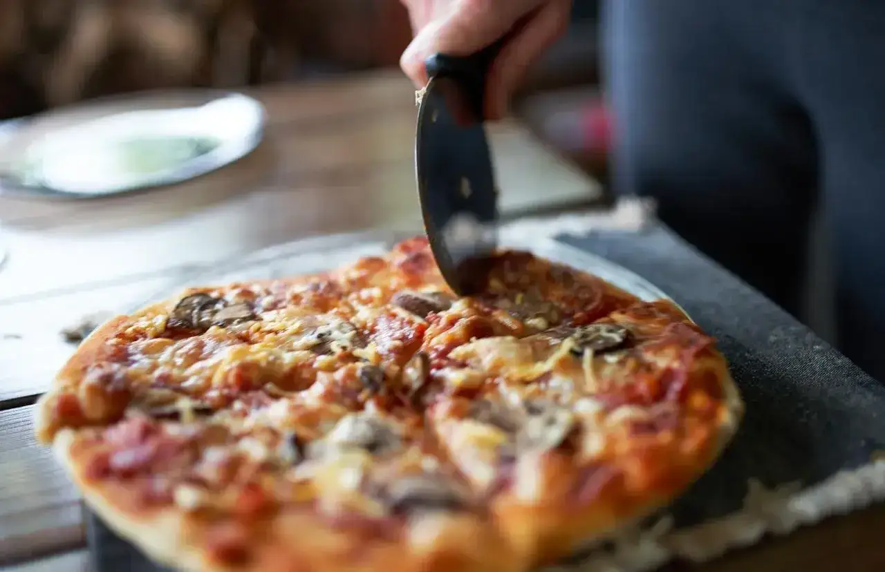 Krojona pizza z grzybami i serem. Idealne proporcje ciasta na pizzę sprawiają, że jest chrupiąca i pyszna.
