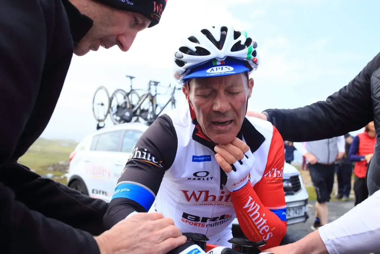 Kolarz w kasku i stroju z logo 