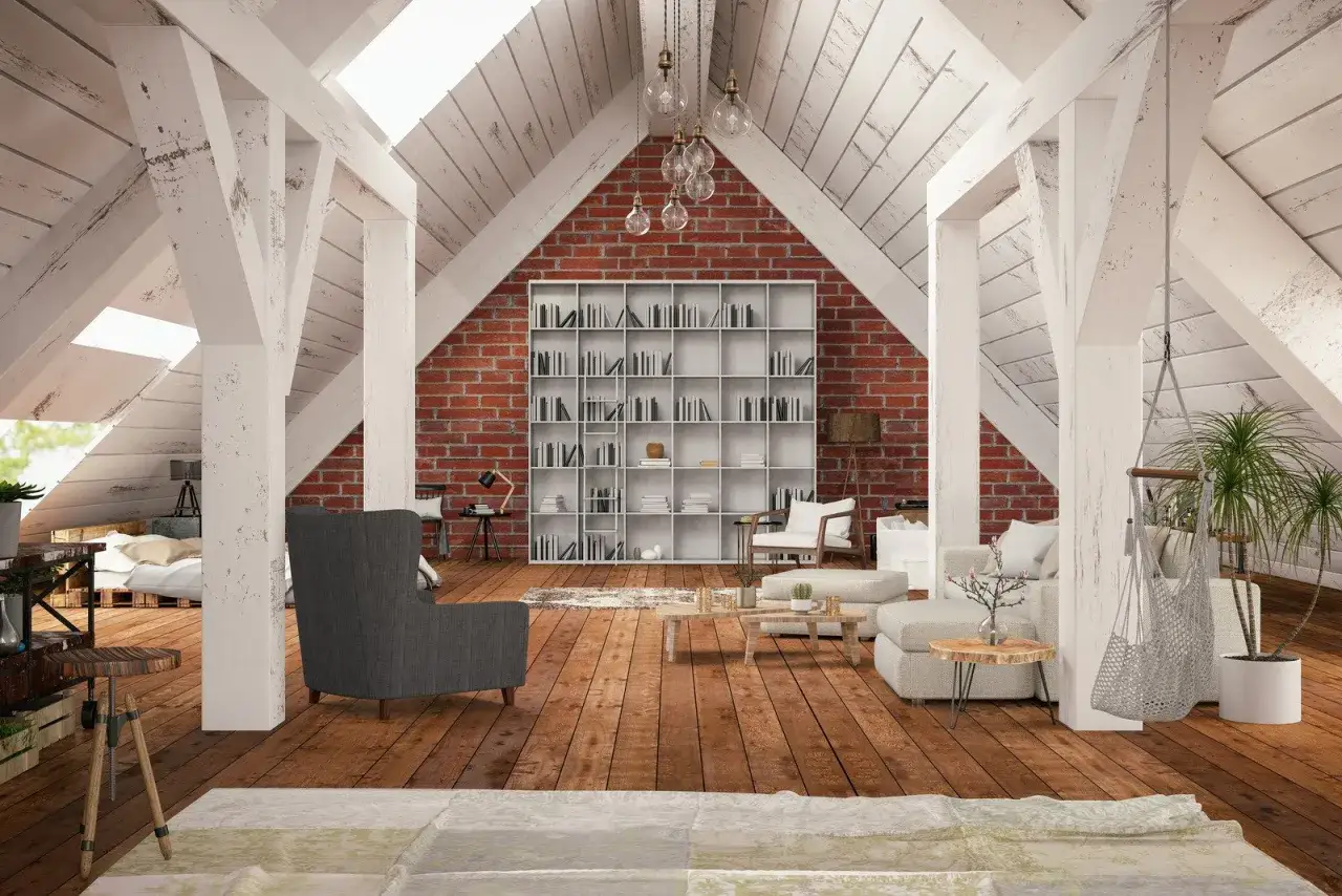Przytulne aranżacje poddasza: salon z biblioteczką, wygodnymi sofami i ł&oacute;żkiem. Drewniana podłoga i ceglana ściana tworzą ciepły klimat.