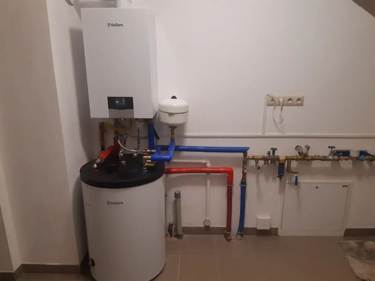 Instalacja grzewcza Vaillant z zasobnikiem. Widać zawory i rury, które pomagają zrozumieć, jak dopuścić wodę do pieca gazowego Vaillant.