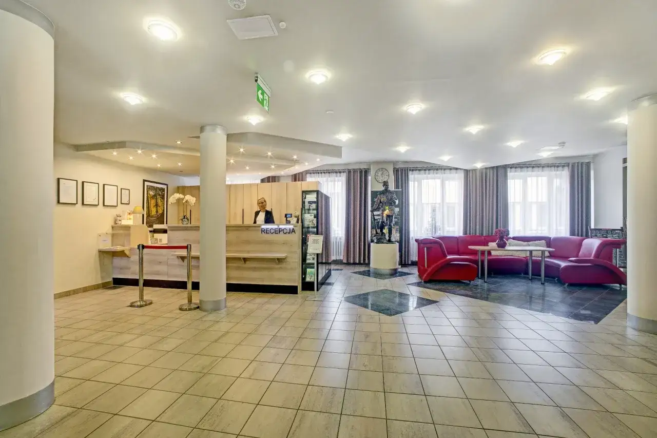 Recepcja w górniczym sanatorium. Obok recepcjonistki stoi posąg górnika.