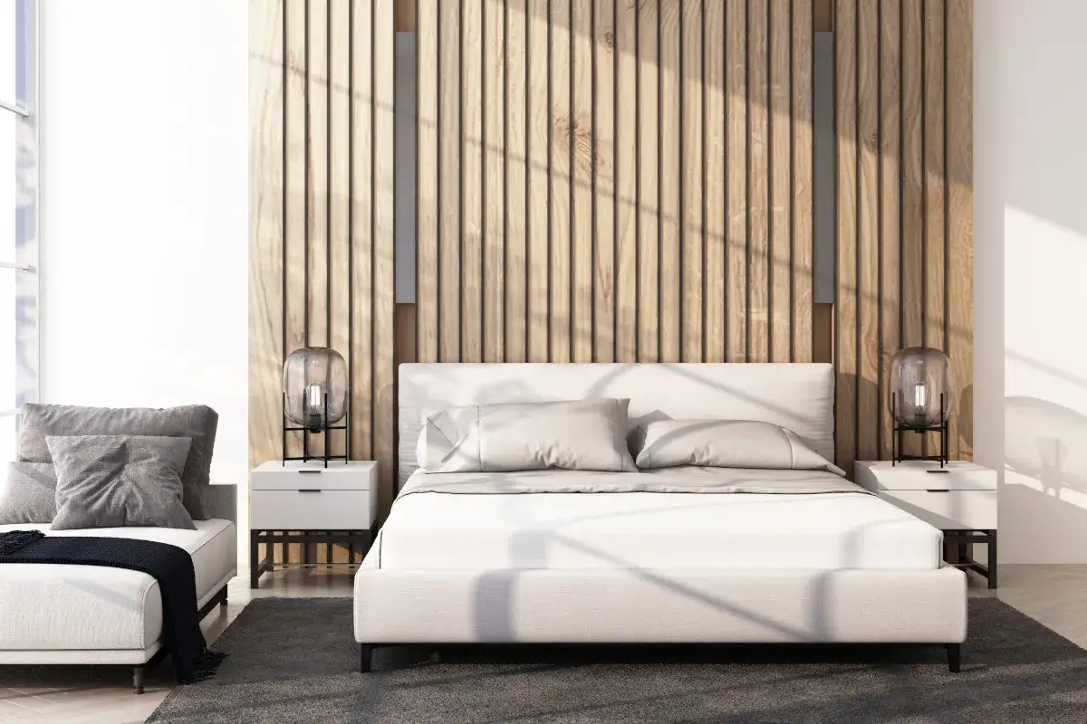 Nowoczesna ściana w sypialni aranżacje: ł&oacute;żko z białym zagł&oacute;wkiem, drewniana boazeria, stoliki nocne z lampami.
