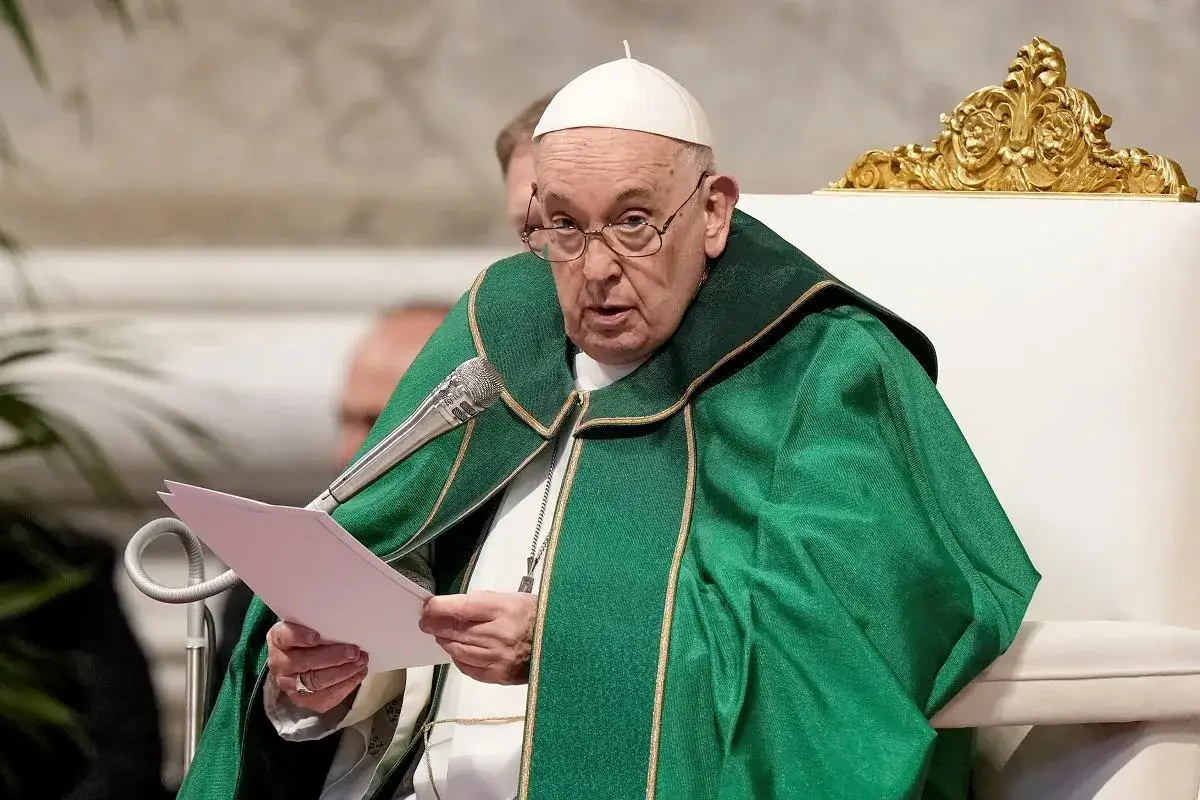 Papież Franciszek w zielonej szacie, z mikrofonem i dokumentem. Kto jest nad biskupem? To on sam, głowa Kościoła.