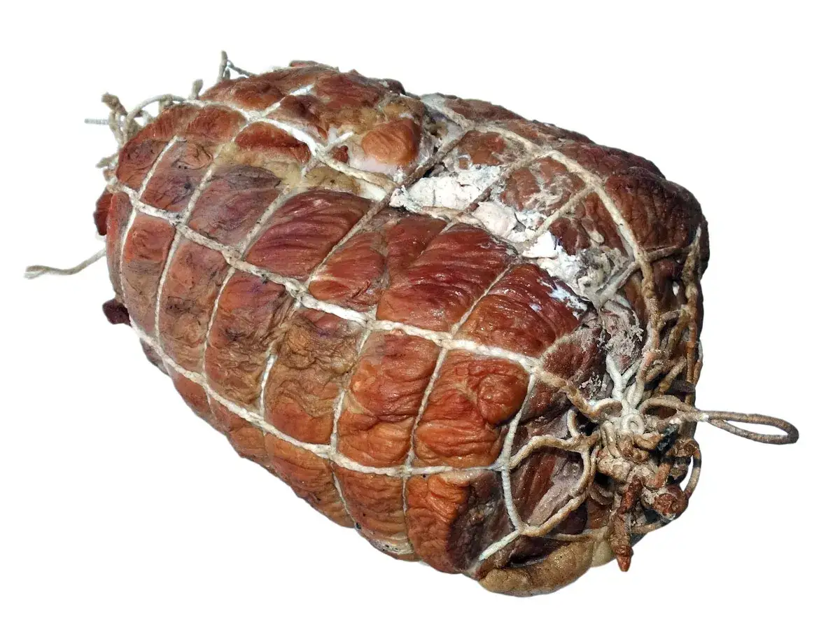 Wędzona szynka w siatce, gotowa do dalszej obr&oacute;bki. Zastanawiasz się, jak długo wędzić szynkę, by uzyskać idealny smak?