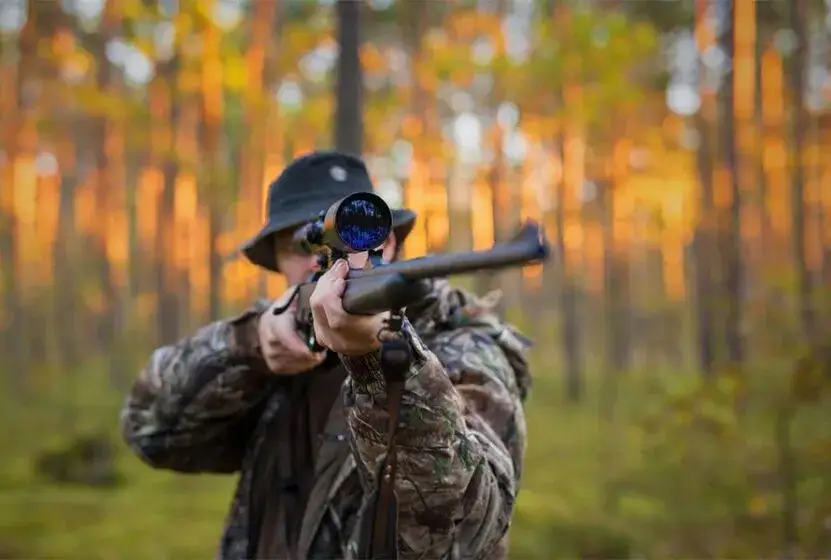 myśliwy z telefonem w lesie