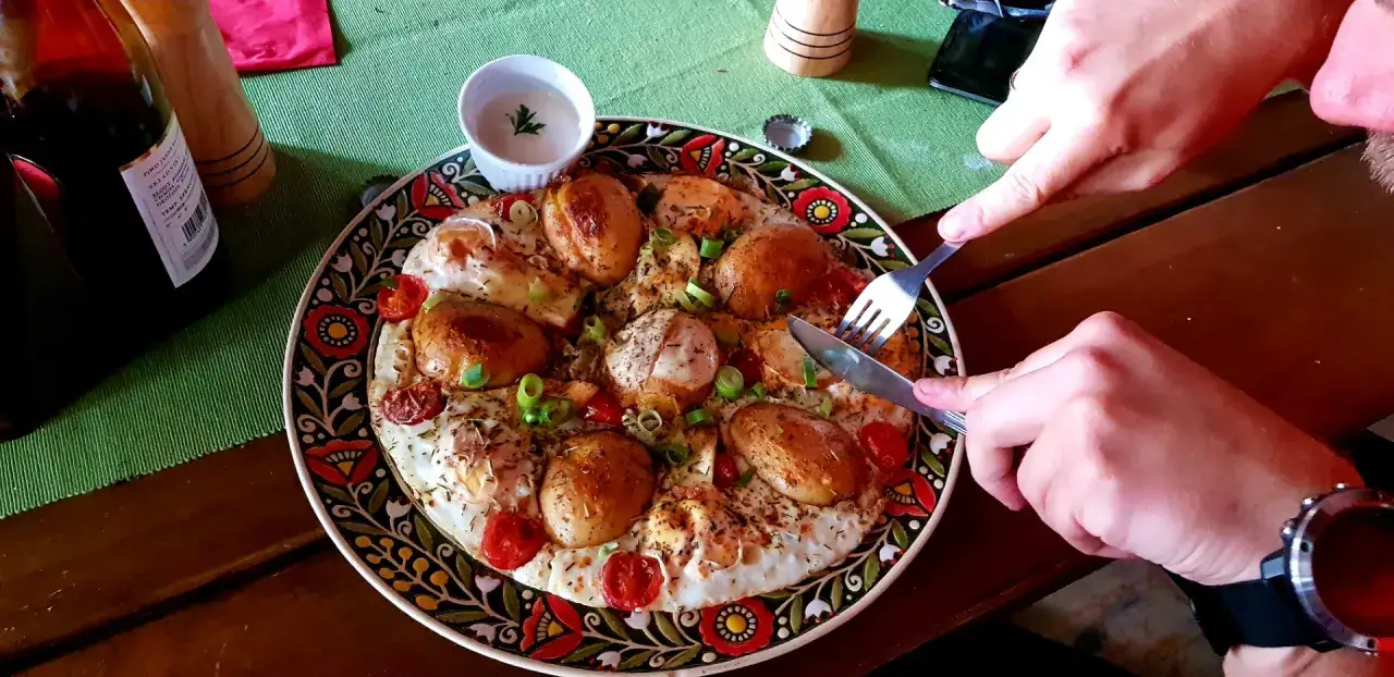 Pyszne jajka sadzone z ziemniakami i pomidorkami na ludowym talerzu. Wspaniała gościna na wierchu!