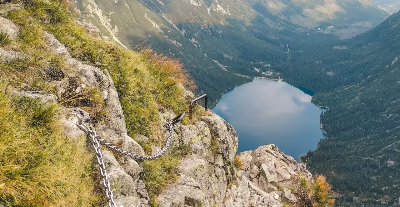 Łańcuchy ułatwiają przejście przez skalistą przełęcz pod Chłopkiem, z widokiem na jezioro Morskie Oko.