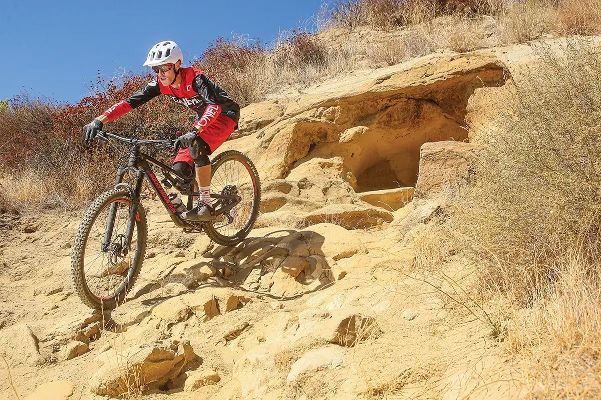 Kolarz zjeżdża po kamienistym zboczu, pokazując, co to **enduro** – jazda pełna adrenaliny i wyzwań.