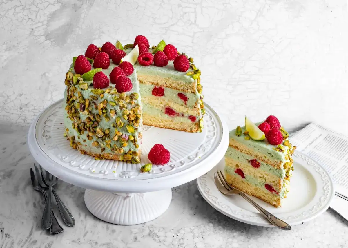 Pyszny tort z malinami i pistacjami, którego sercem jest delikatna **masa pistacjowa**.