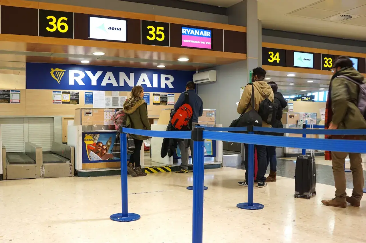 Kasa Ryanair na lotnisku. Ludzie stoją w kolejce, zastanawiając się, ile wcześniej trzeba być na lotnisku Ryanair.
