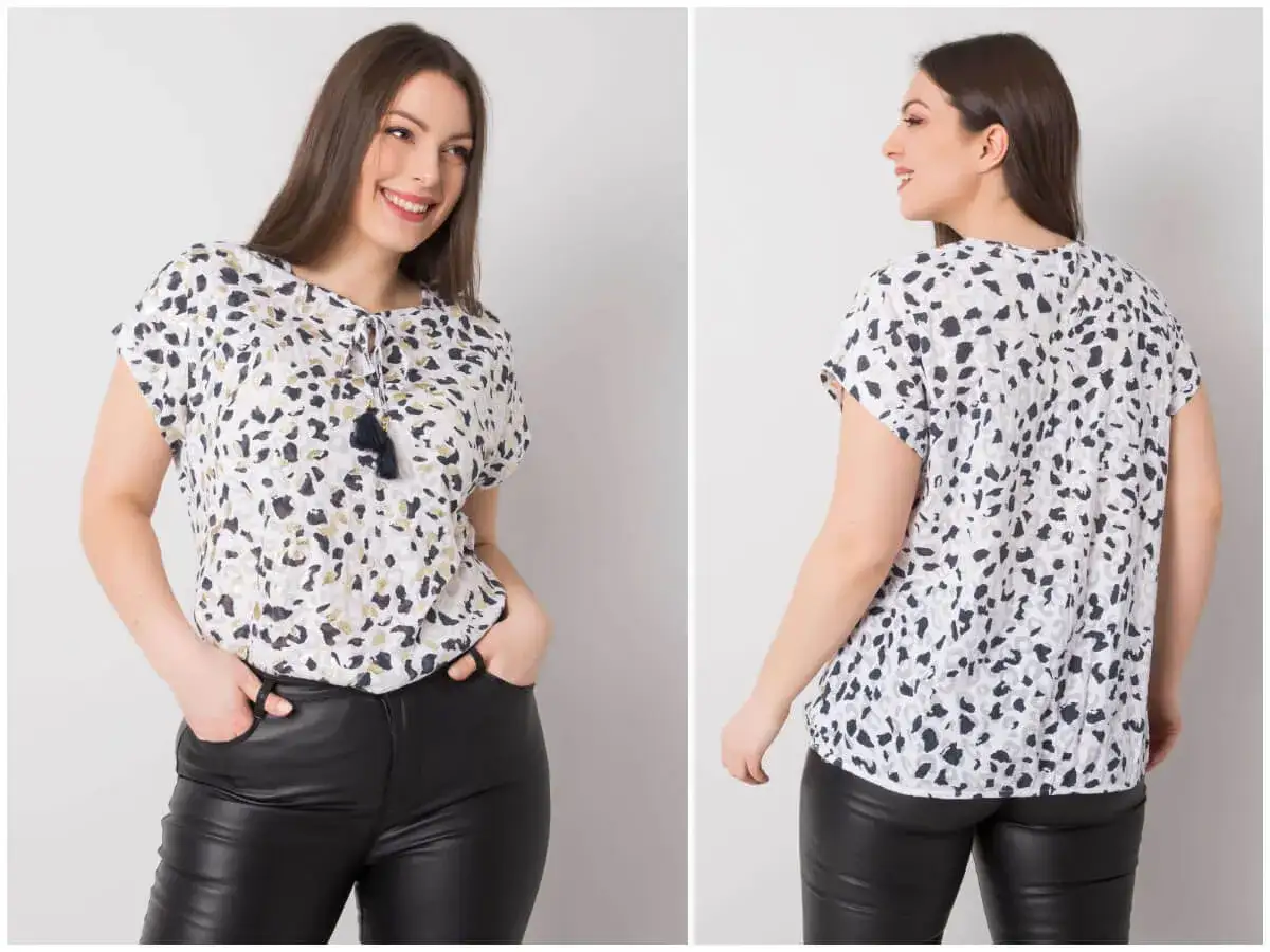 Uśmiechnięta kobieta w stylowej bluzce damskiej plus size z modnym wzorem i czarnych skórzanych spodniach.