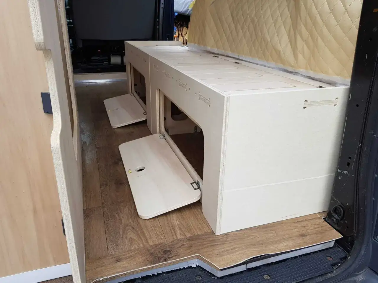 Drewniane meble do kampera, w tym ł&oacute;żko ze schowkami, to praktyczne gadżety ułatwiające podr&oacute;żowanie.