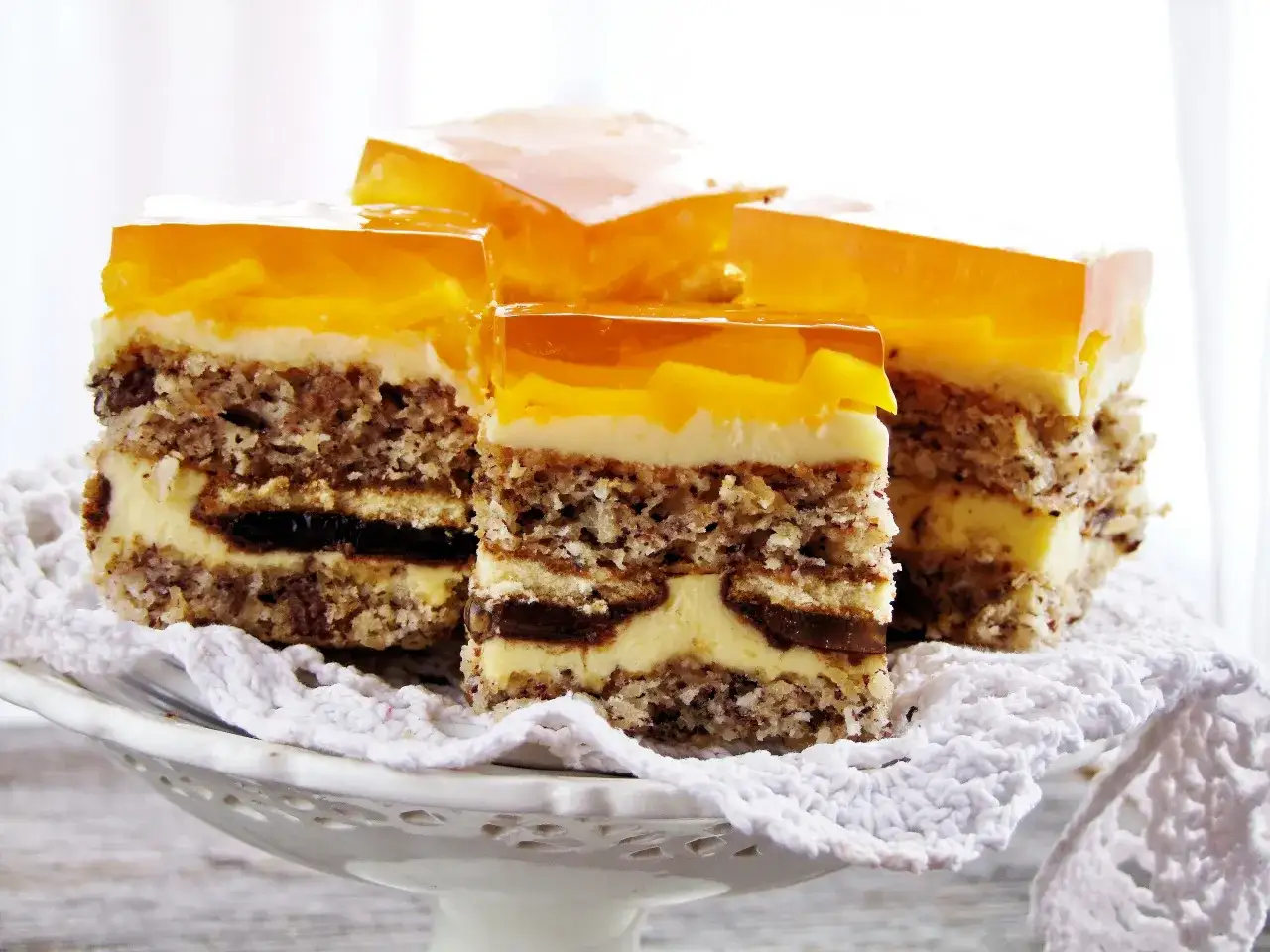 Pyszne ciasto kora dębu z warstwami biszkoptu, kremu, czekolady i galaretki z owocami.