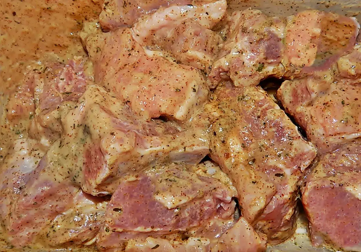 Kawałki mięsa w marynacie musztardowo miodowej na grilla, gotowe do pieczenia.