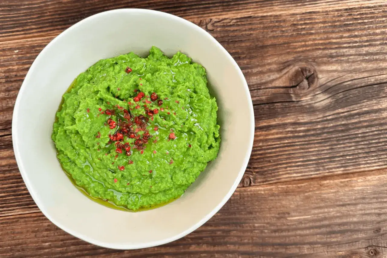 Zielony groszek dla niemowlaka, gładkie puree z groszku z odrobiną r&oacute;żowego pieprzu, idealne na pierwszy posiłek.