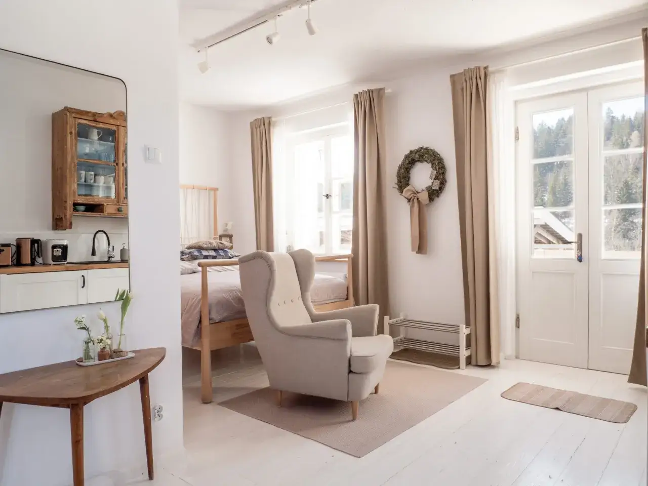 Przytulne wnętrze apartament&oacute;w Trzy Morza pod Tr&oacute;jmorskim Wierchem. Jasne pokoje, wygodny fotel i widok na g&oacute;ry.