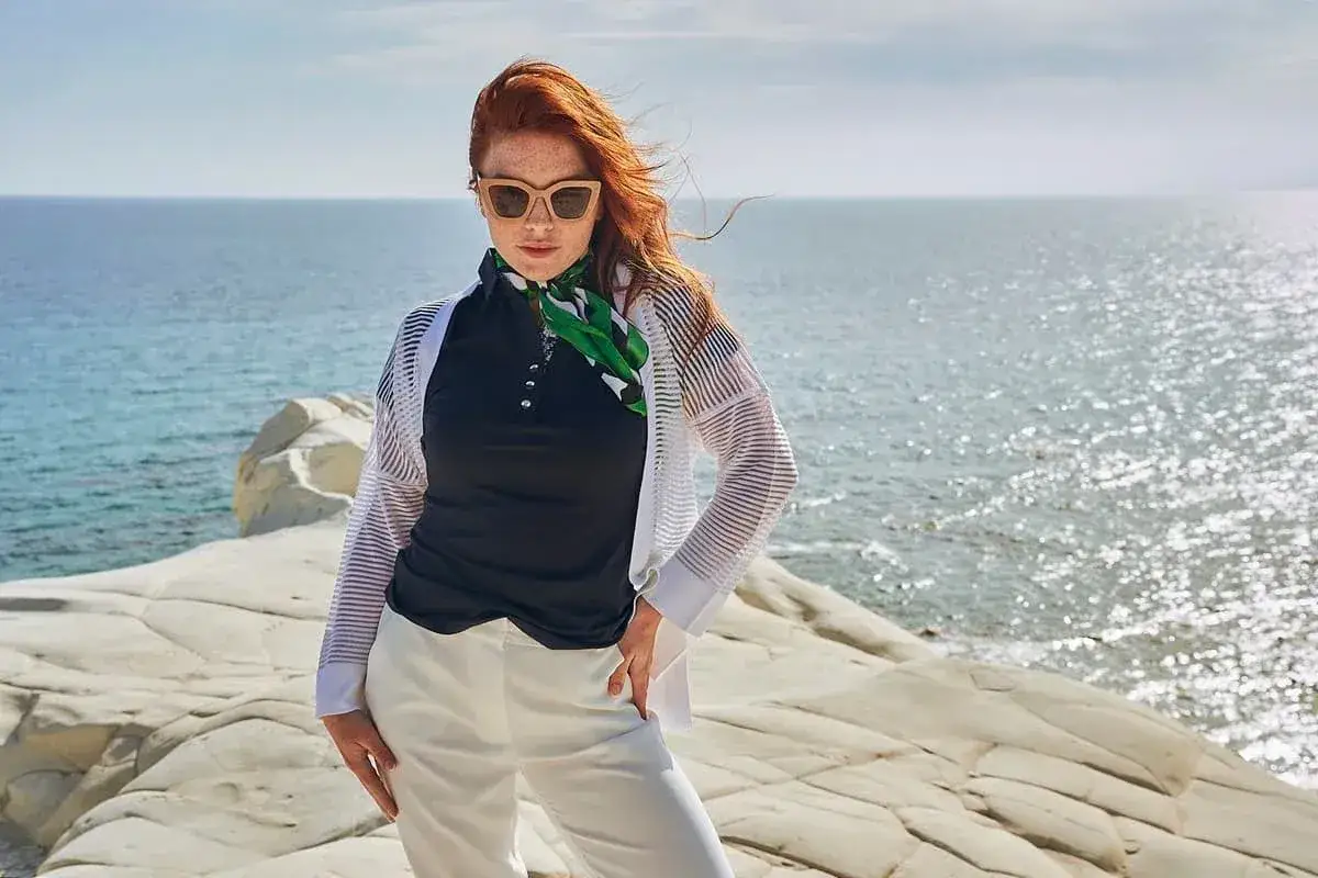 Elegancka stylizacja nad morze: białe spodnie, czarna bluzka polo, transparentna narzutka i zielony szalik. Idealnie, jak się ubrać nad morze!
