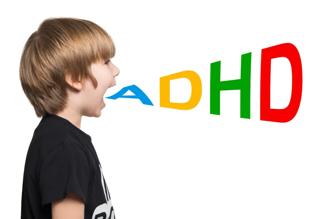 Chłopiec z otwartymi ustami, z których wydobywają się kolorowe litery tworzące napis ADHD. Obraz symbolizuje objawy ADHD u dzieci.
