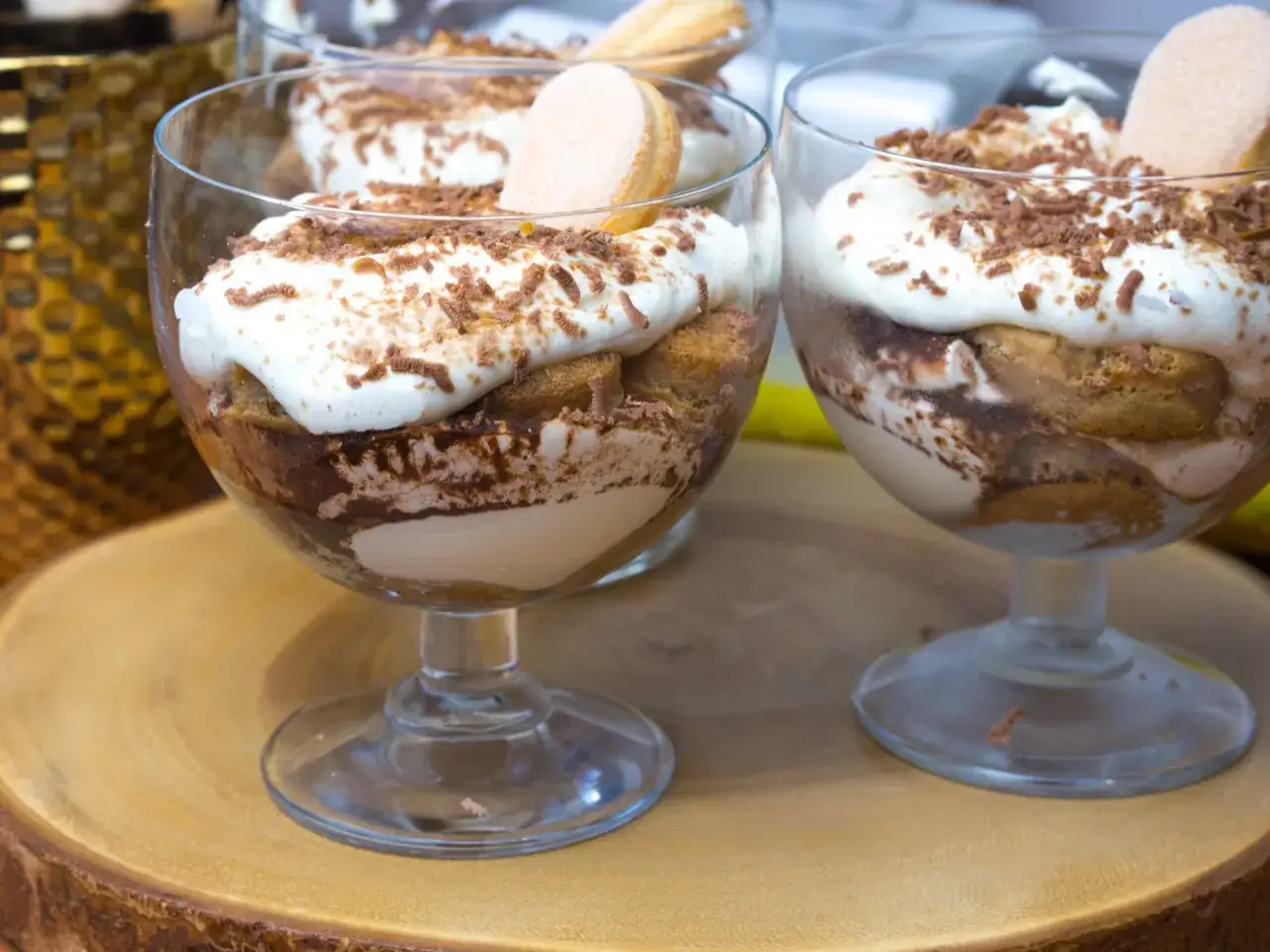 Pyszne tiramisu bez jajek w pucharkach, udekorowane biszkoptami i startą czekoladą. Idealne na deser.